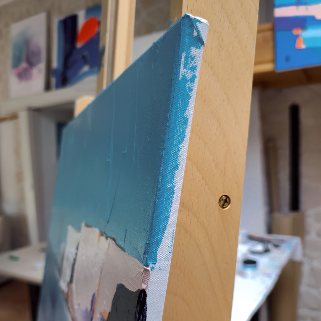 Gros plan sur la tranche peinte et le relief au couteau d'un tableau contemporain
