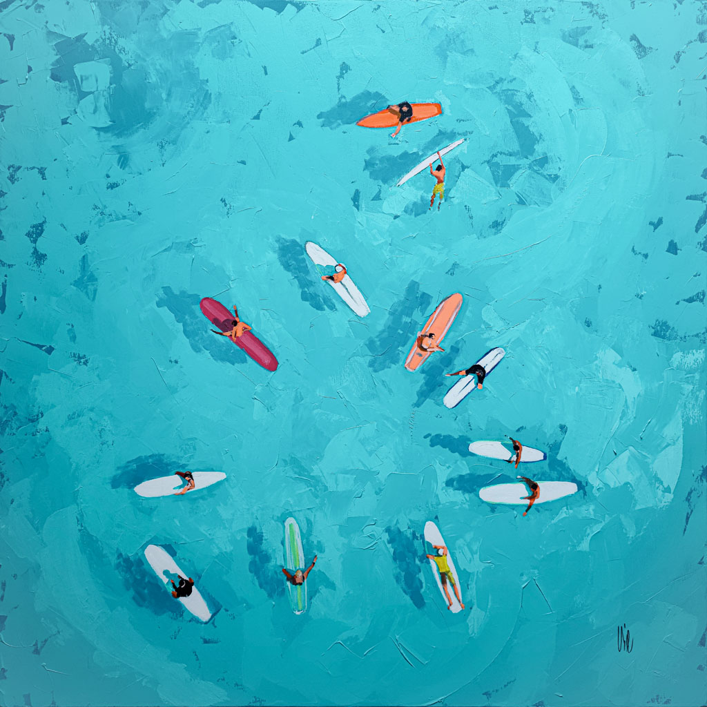 Vue aérienne de surfeurs sur des planches colorées, dispersés dans les eaux d'un bleu éclatant de l'océan.