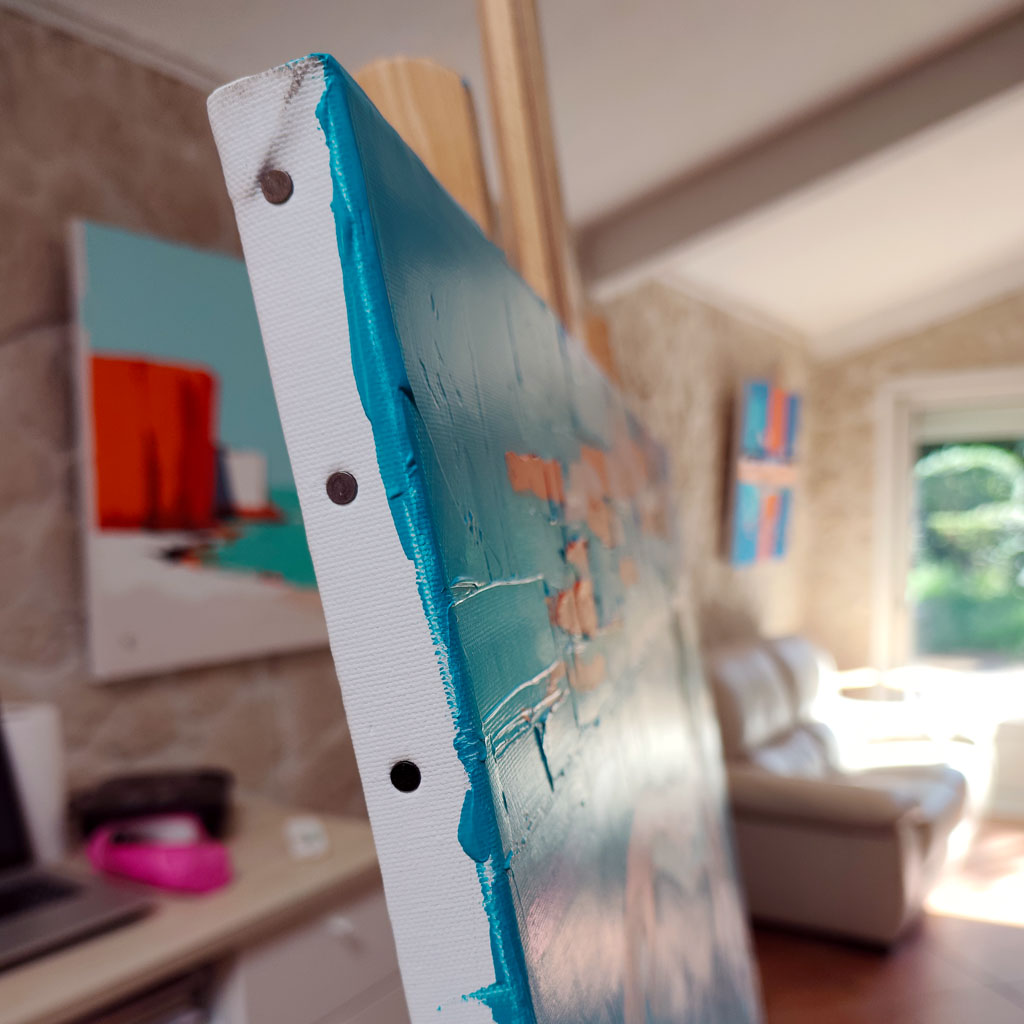 Zoom sur la tranche peinte en bleu turquoise et les reliefs de matière de la peinture acrylique