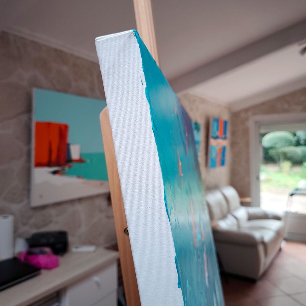 Vue de profil de la peinture Surf Esprit Libre sur un châssis en toile épais posé sur un chevalet en bois dans un atelier